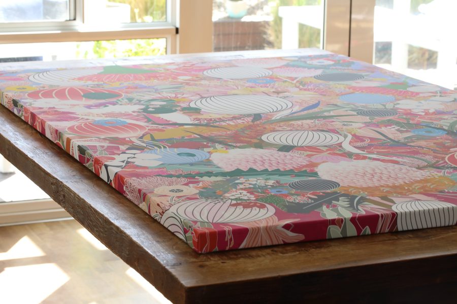 A finished canvas lying on a timber table, printed right to the edge