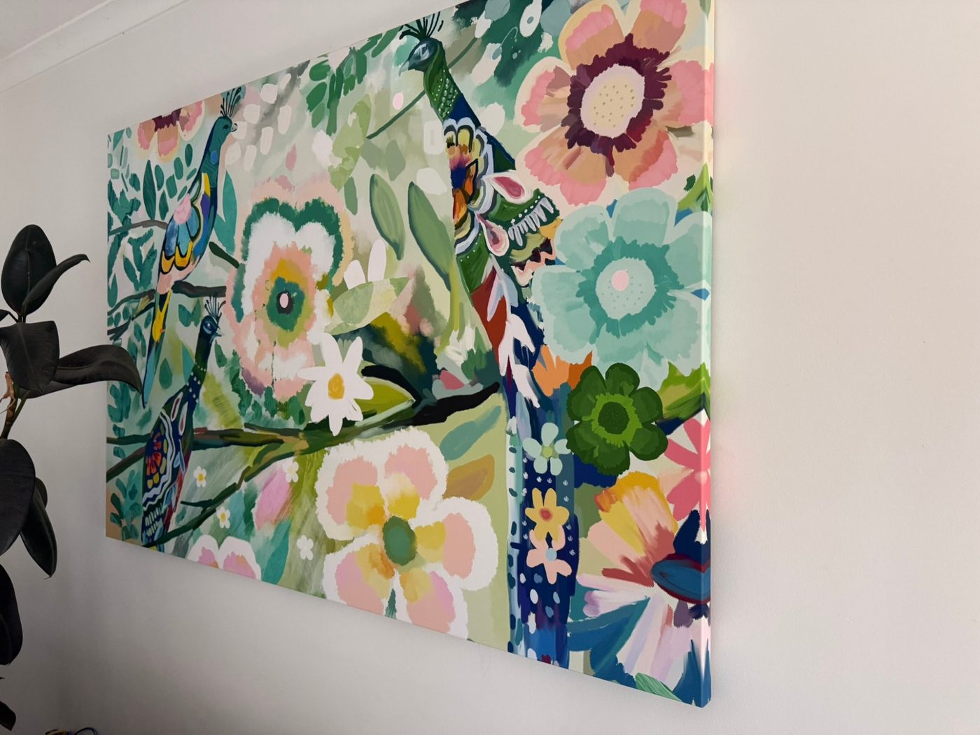 A large floral canvas on a white wall, the design continuing round its edge